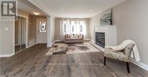 Oshawa (O'neill) apartment for rent - A well-lit, spacious living room with a couch, chair, and a rug.