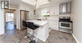 Oshawa (O'neill) apartment for rent - A kitchen with white cabinets and a black bar stool.