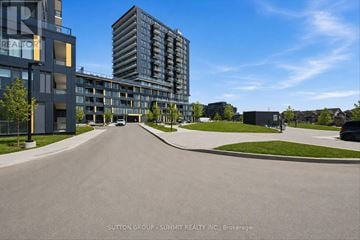 Burlington (Alton) condo for rent - A street view of a residential area with apartment buildings and a clear blue sky.