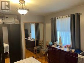 Toronto (Rockcliffe-Smythe) apartment for rent - A bedroom with a bed, dresser, and mirror.