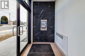 Hamilton (Lakeshore) condo for rent - A realtor's office with a marble wall and a digital display.