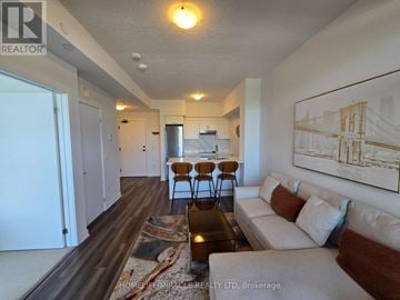 Hamilton (Lakeshore) condo for rent - A living room with a couch, coffee table, and a painting on the wall.