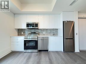 Brantford condo for rent - A modern kitchen with white cabinets and stainless steel appliances.