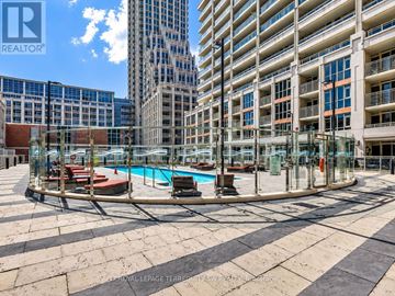 Toronto (Niagara) condo for rent - A swimming pool area with a glass enclosure and a pool table in the middle.