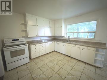 King apartment for rent - A kitchen with white cabinets and appliances.