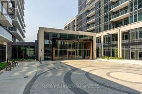Milton (Tm Timberlea) condo for rent - A modern building entrance with a circular walkway in front.