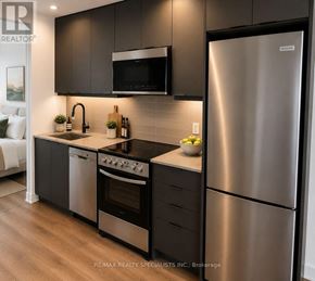 Milton (Tm Timberlea) condo for rent - A modern kitchen with a stainless steel refrigerator and black cabinets.