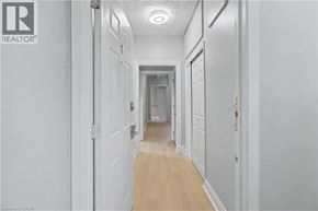 Hamilton apartment for rent - A long hallway with white walls and wood flooring.