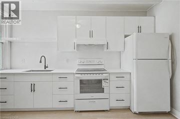 Hamilton apartment for rent - A white kitchen with a refrigerator on the right.