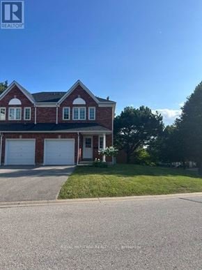 Whitby (Pringle Creek) townhouse for rent - A house with a red brick facade and white garage doors.
