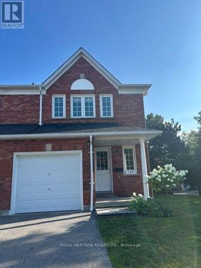 Whitby (Pringle Creek) townhouse for rent - A red brick house with a white garage door and windows.
