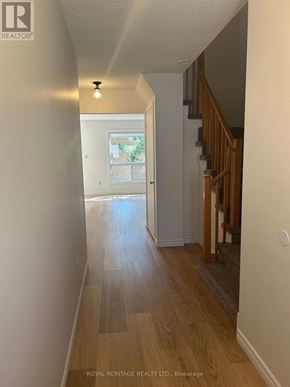 Whitby (Pringle Creek) townhouse for rent - A hallway with wood floors and a staircase.