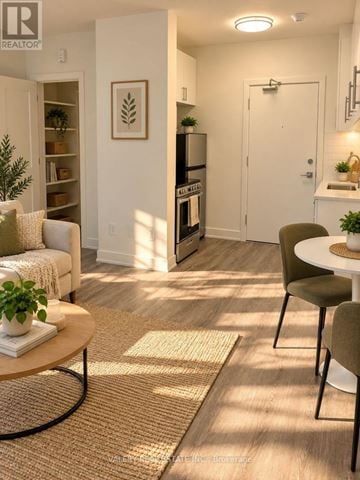 Ottawa condo for rent - A living room with a white couch, a coffee table, and a dining table with chairs.