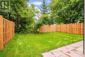 South Glengarry apartment for rent - A backyard with a wooden fence and a brick pathway.