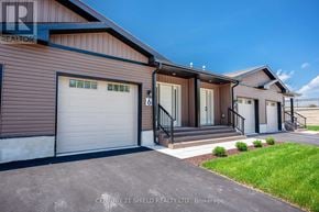 South Stormont townhouse for rent - A modern house with a brown siding and a white garage door is for sale.