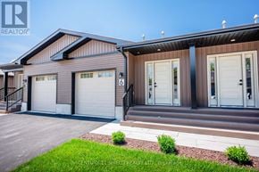 South Stormont townhouse for rent - A modern house with a brown and beige exterior and a garage door numbered 6.
