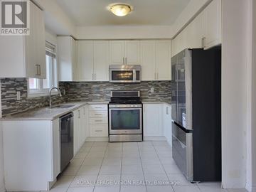 Milton (Be Beaty) apartment for rent - A kitchen with white cabinets and a black refrigerator.