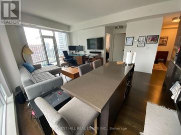 Toronto (Waterfront Communities) condo for rent - A living room with a grey couch and a brown table.