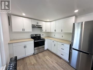 Welland (Lincoln/Crowland) apartment for rent - A kitchen with white cabinets and a stainless steel refrigerator.