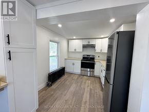 Welland (Lincoln/Crowland) apartment for rent - A kitchen with white cabinets and a black refrigerator.