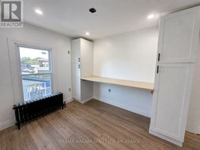 Welland (Lincoln/Crowland) apartment for rent - A room with a window, radiator, and a bench under a cabinet.
