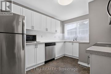 Ottawa apartment for rent - A kitchen with white cabinets and a refrigerator.