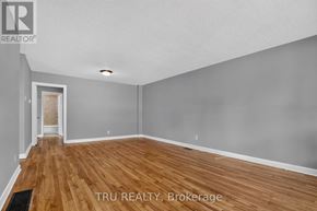 Ottawa apartment for rent - A room with wooden flooring and a TRU REALTY logo.