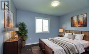 Niagara Falls (Oldfield) apartment for rent - A bedroom with a bed, nightstand, lamp, and a plant.