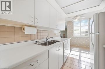 Hamilton condo for rent - A kitchen with white cabinets and a sink.