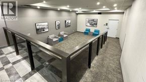 Hamilton condo for rent - A realtor's office with a desk, chairs, and pictures on the wall.