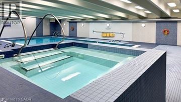 Hamilton condo for rent - A swimming pool in a well lit indoor swimming pool.