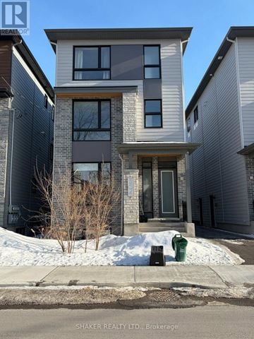 Ottawa fourplex for rent - A modern house with a grey and brown exterior is for sale in Brockage.