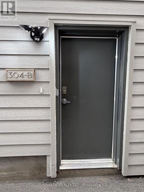 Ottawa fourplex for rent - A door with a black handle and a sign above it that says 304-B.