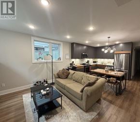 Ottawa fourplex for rent - A well-lit living room with a couch, coffee table, and kitchen area in the background.
