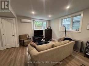 Ottawa fourplex for rent - A living room with a beige couch, a brown armchair, and a black coffee table.