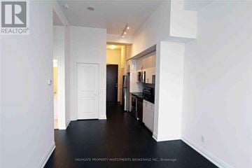 Markham (Wismer) condo for rent - A spacious kitchen with white cabinets and black appliances.