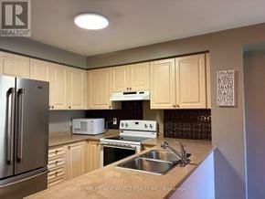 Ajax (South East) townhouse for rent - A kitchen with wooden cabinets and a stainless steel refrigerator.