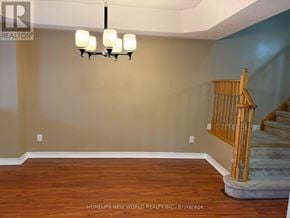 Ajax (South East) townhouse for rent - A room with wooden floors and a chandelier hanging from the ceiling.