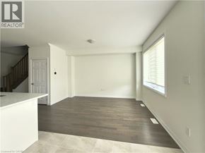 Breslau townhouse for rent - A spacious room with wooden flooring and a staircase on the left side.