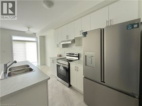 Breslau townhouse for rent - A modern kitchen with stainless steel appliances and white cabinets.