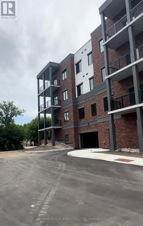 Clearview (Creemore) condo for rent - A multi-story residential building with a parking lot in front.