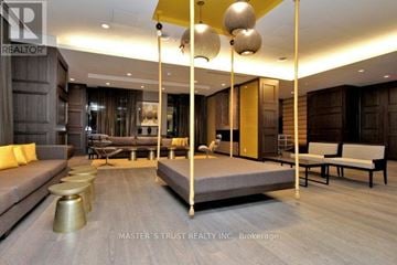 Toronto (Waterfront Communities) condo for rent - A living room with a grey sofa and a yellow accent wall.