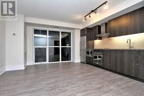 Toronto (Waterfront Communities) condo for rent - A spacious kitchen with dark wood cabinets and a modern design.