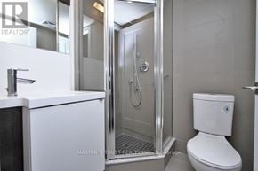 Toronto (Waterfront Communities) condo for rent - A white toilet sits next to a walk-in shower in a bathroom.