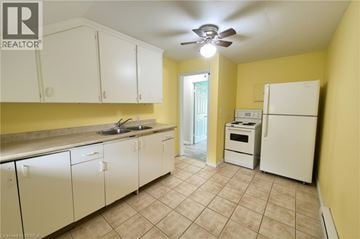 Brantford apartment for rent - A kitchen with white cabinets and a white fridge.