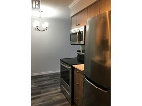 New Westminster apartment for rent - A kitchen with a stainless steel refrigerator and wooden cabinets.