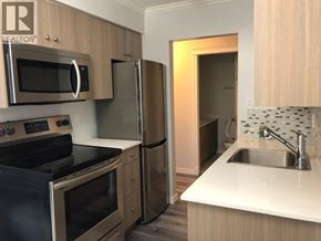 New Westminster apartment for rent - A kitchen with a stove, microwave, refrigerator, and sink.