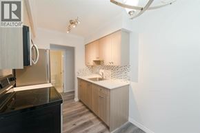 New Westminster apartment for rent - A modern kitchen with a black stove top oven and wooden cabinets.