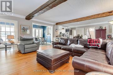 Whitchurch-Stouffville apartment for rent - A living room with a brown leather couch and a grey armchair.