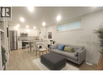 Vancouver apartment for rent - A living room with a grey couch and a white chair.